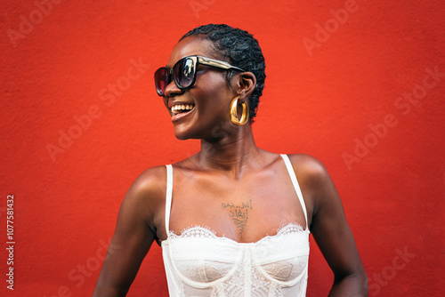 Black woman smiling in front of a bold red background photo