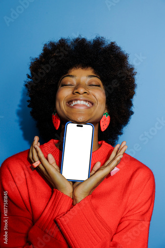 Woman holding smartphone with closed eyes and big smile photo