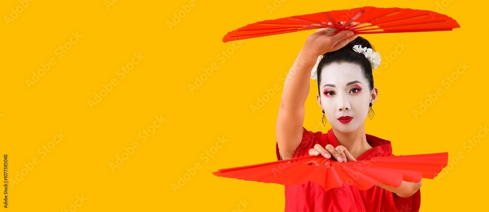 Beautiful young geisha holding fans on yellow background with space for text Beautiful young geisha holding fans on yellow background with space for text