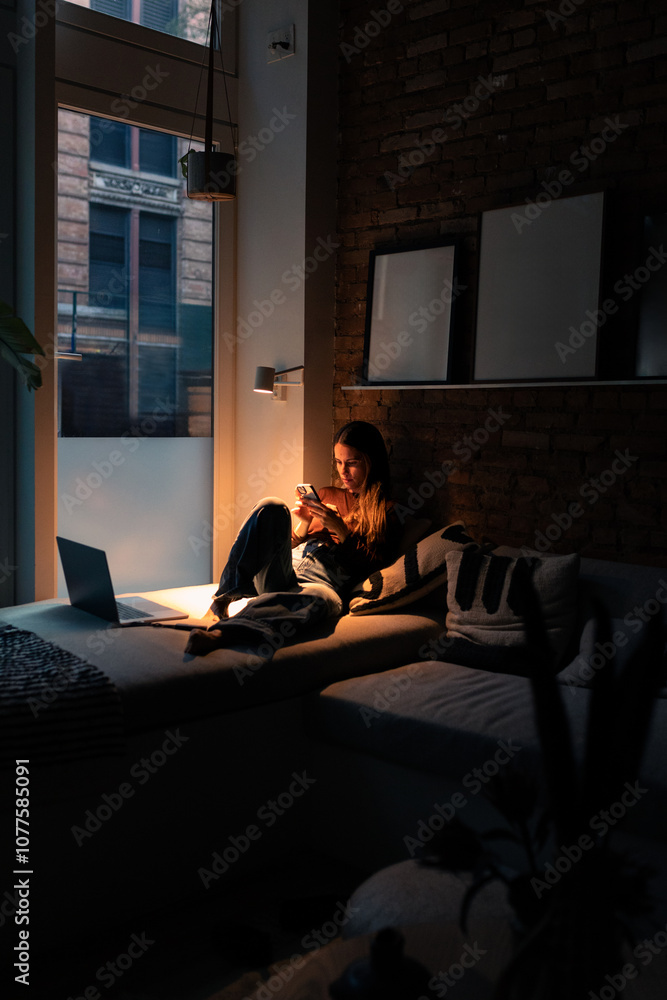 A remote worker uses her smartphone to attend her job from her home A remote worker uses her smartphone to attend her job from her home