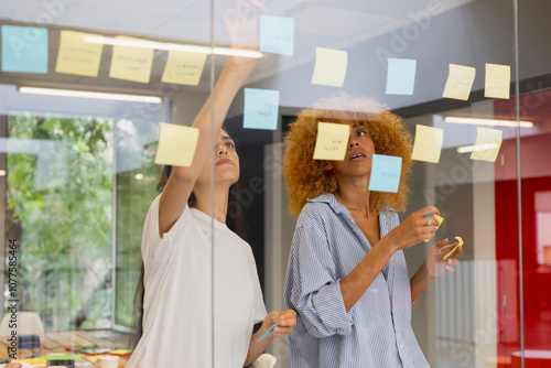 Team brainstorming session with sticky notes on glass photo