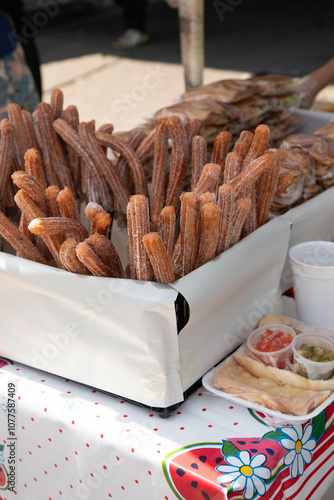 Churros at a street vendor stand with a colorful tablecloth  photo