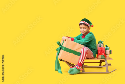 Cute little elf with sled a...