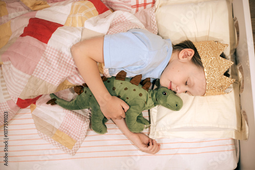 Sleeping girl in crown and toy in bed. Flash photo shot. photo