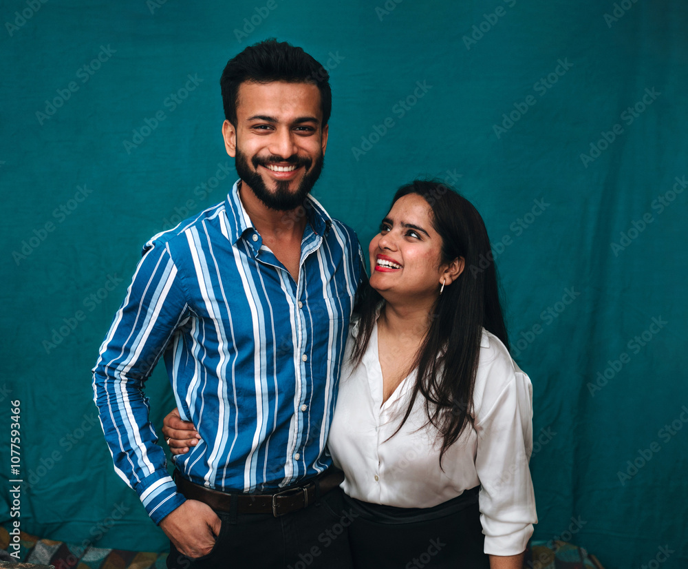 Portrait of Indian students against blue backdrop.