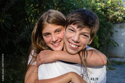 Smiling girl and her disabled brother outdoors photo