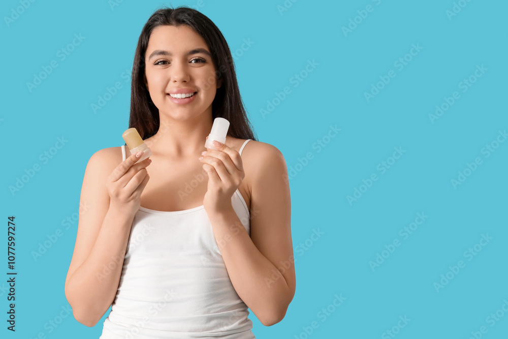 Happy young woman with crystal deodorants on blue background Happy young woman with crystal deodorants on blue background
