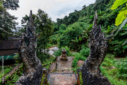 Natural background of ancient sculptures of religious tourist attractions, Naga statues, old churches by the natural waterfall from the high mountain, Wat Phalat, the way up to Doi Suthep, Chiang Mai photo