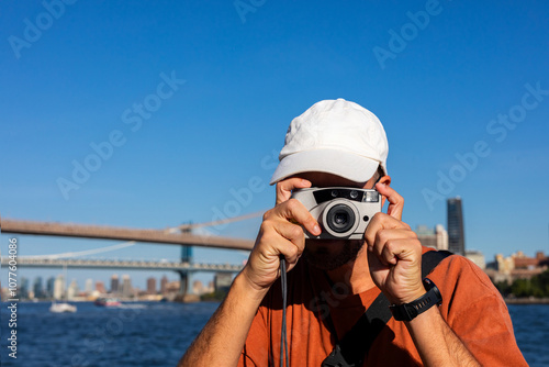 Photographer uses a camera during a touristic trip to Brooklyn Bridge photo