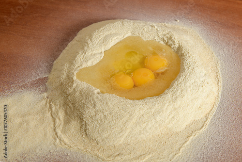 Whole wheat flour on the table with eggs for making pasta  photo