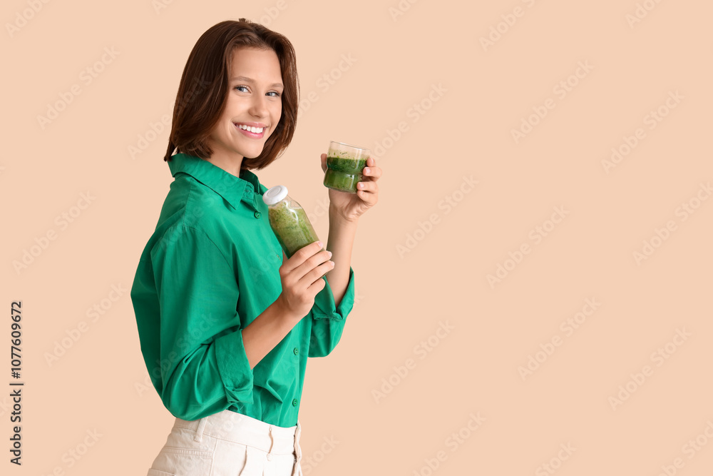 Beautiful young happy woman with bottle and cup of healthy green smoothie on beige background. Diet concept Beautiful young happy woman with bottle and cup of healthy green smoothie on beige background. Diet concept