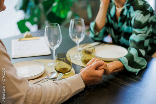 Couple holding hands while having romantic dinner date photo