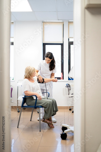 Nurse checking patient's blood pressure photo