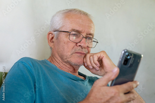 Elderly man looking at smartphone photo