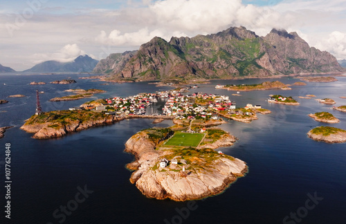 Football field and lighthouse in lofoten islands, norway, under cloudy sky
