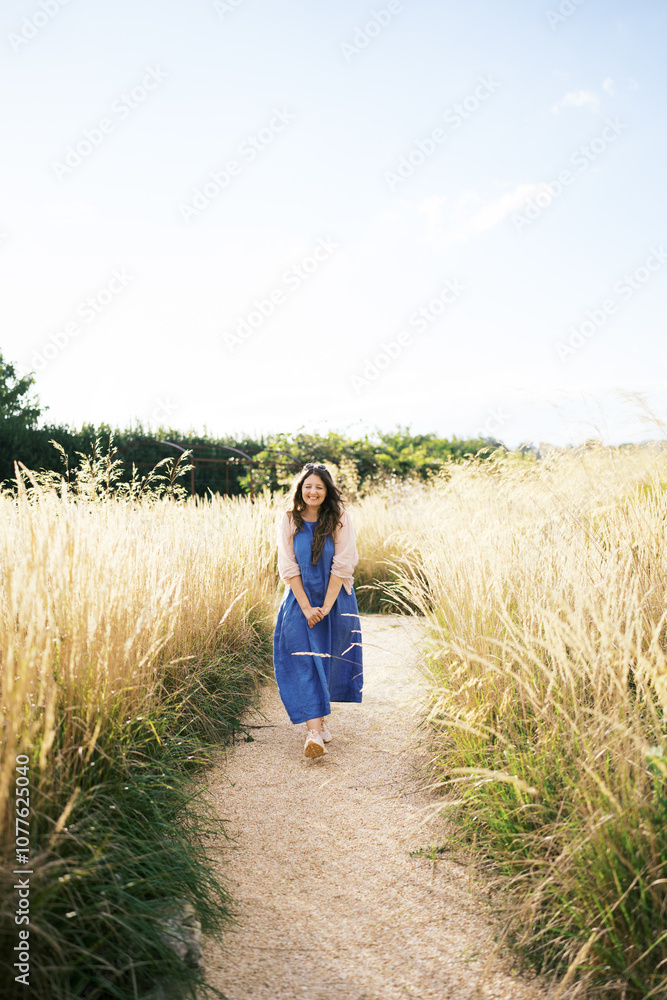Person dressed in blue walking on a path in nature. Person dressed in blue walking on a path in nature.
