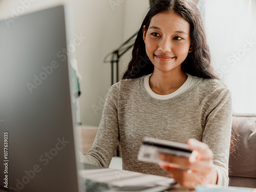 Young Woman Shopping Online with Laptop and Credit Card photo