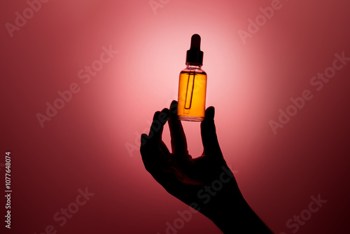 Female hand holding dropper bottle with anti aging face serum. photo