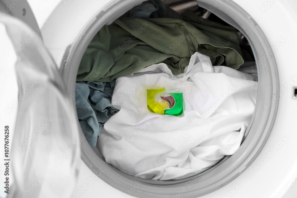Open washing machine with clothes and laundry detergent, closeup Open washing machine with clothes and laundry detergent, closeup