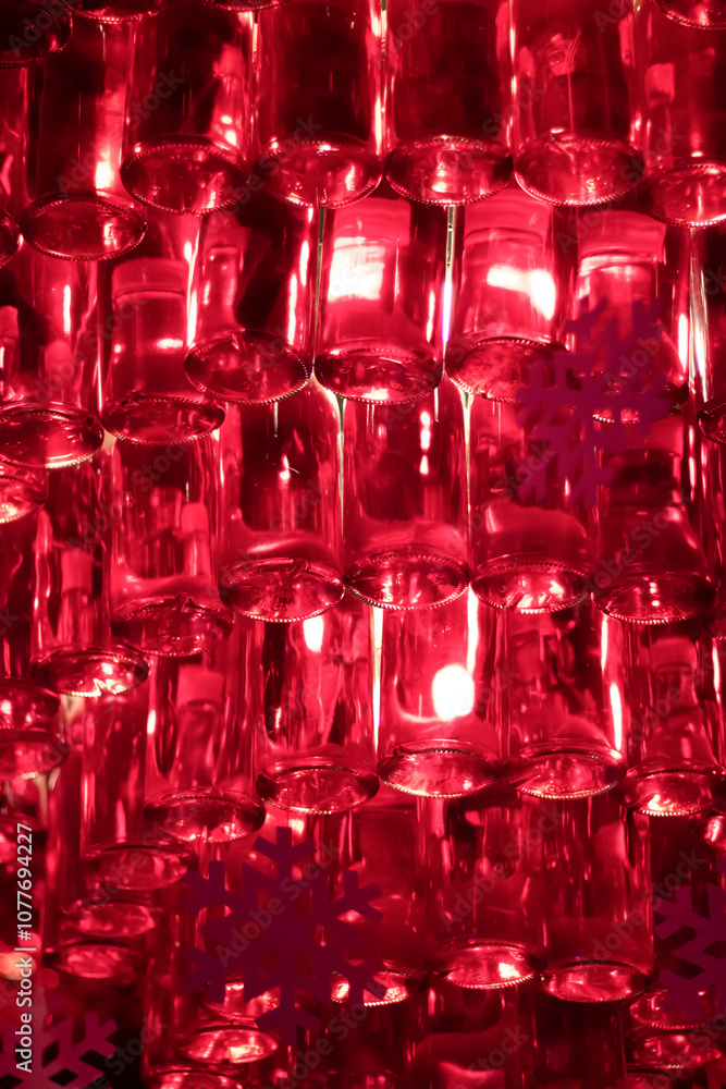 Rows of red-lit translucent glass bottles hang suspended, creating a festive, vibrant atmosphere with snowflake accents, ideal for winter holiday and New Year themes.
Rows of red-lit translucent glass bottles hang suspended, creating a festive, vibrant atmosphere with snowflake accents, ideal for winter holiday and New Year themes.