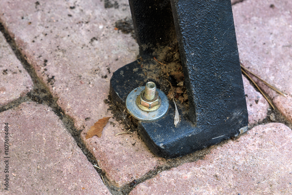 A bolt is sitting on a brick floor