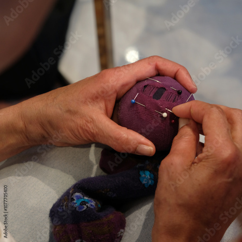 Woman darning socks using pin cushion