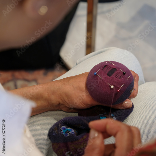 Woman darning socks using pin cushion