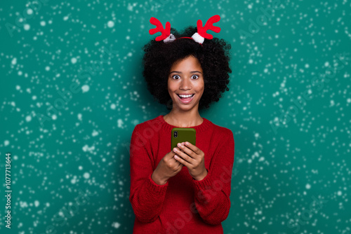 Photo of impressed funny small schoolgirl wear red pullover hairband chatting samsung modern device isolated green color background photo