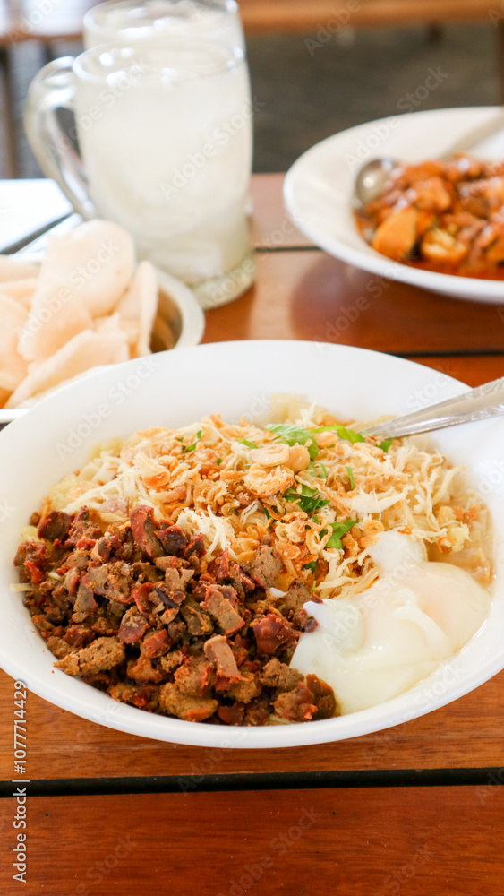 Bubur Ayam: Chicken rice porridge, served with soy sauce, crispy crackers, and fried shallots. Bubur Ayam: Chicken rice porridge, served with soy sauce, crispy crackers, and fried shallots.
