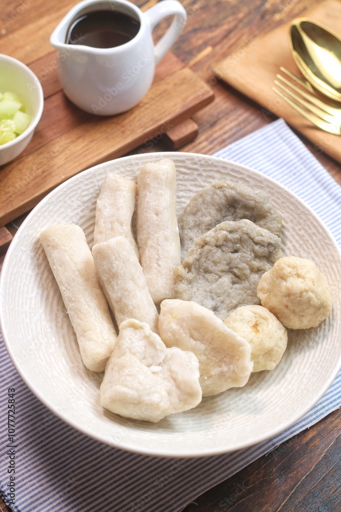 Pempek or empek-empek is a savoury Indonesian fishcake delicacy, made of fish and tapioca, from Palembang, South Sumatera, Indonesia. Pempek is served with rich sweet and sour sauce called cuko Pempek or empek-empek is a savoury Indonesian fishcake delicacy, made of fish and tapioca, from Palembang, South Sumatera, Indonesia. Pempek is served with rich sweet and sour sauce called cuko