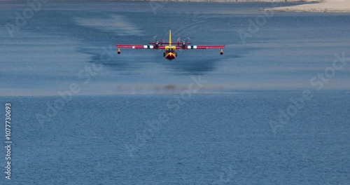 A small plane is flying over a body of water