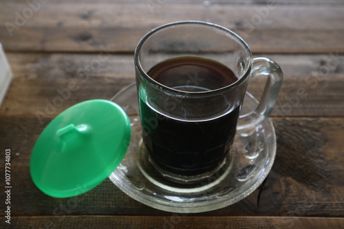 Brewed coffee on a rustic wooden table in a coffee shop (warkop) photo