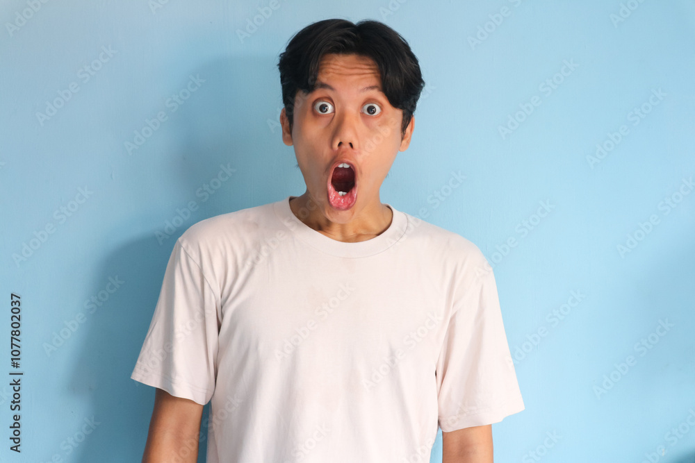 © Zulailar Studio - Shocked face of Asian young man in white t-shirt on a isolated background © Zulailar Studio - Shocked face of Asian young man in white t-shirt on a isolated background
