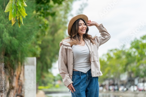 Portrait of an Asian Tourist Woman in Hat and Jacket Smiling Outdoors