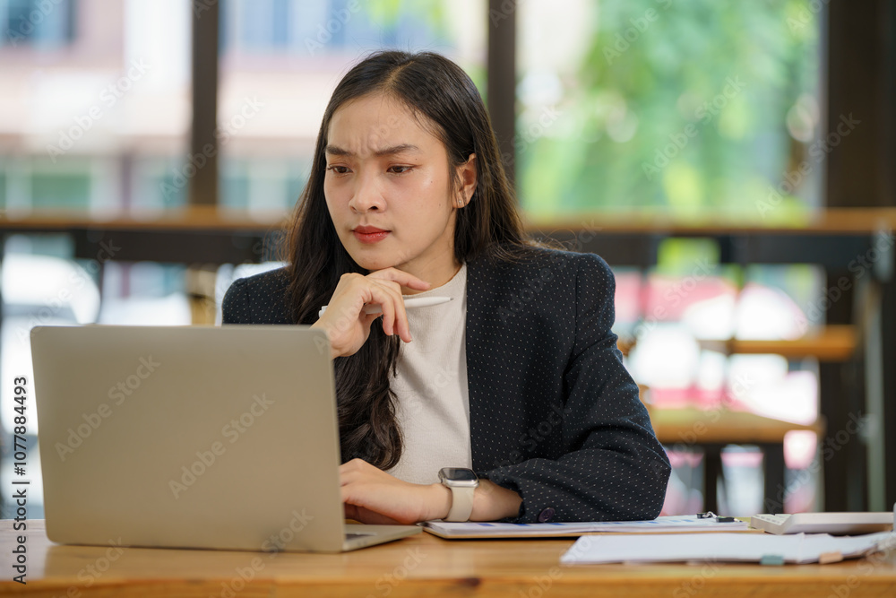 Beautiful Asian businesswoman using a laptop working in an office and depressed. Beautiful Asian businesswoman using a laptop working in an office and depressed.