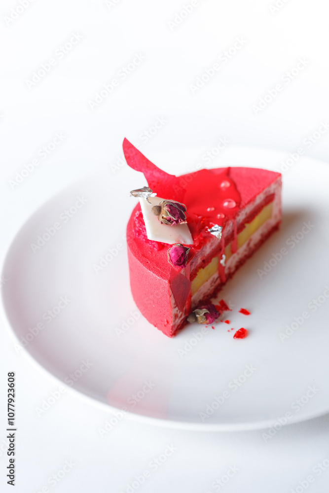 Close-up of delicious red cake in plate on table against white background