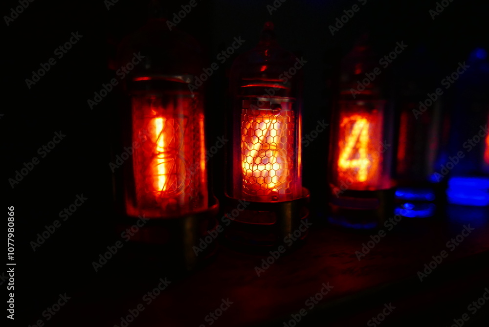 Retro Nixie lamp indicator clock on dark background. The Nixie tube indicator of the numbers of retro style. Retro Nixie lamp indicator clock on dark background. The Nixie tube indicator of the numbers of retro style.