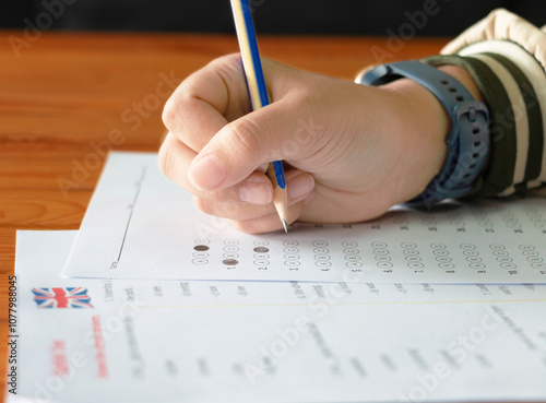 hand holding pencil over bubble answer sheet