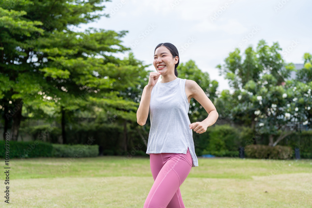 Asian beautiful sportswoman doing running exercise alone in the garden Asian beautiful sportswoman doing running exercise alone in the garden