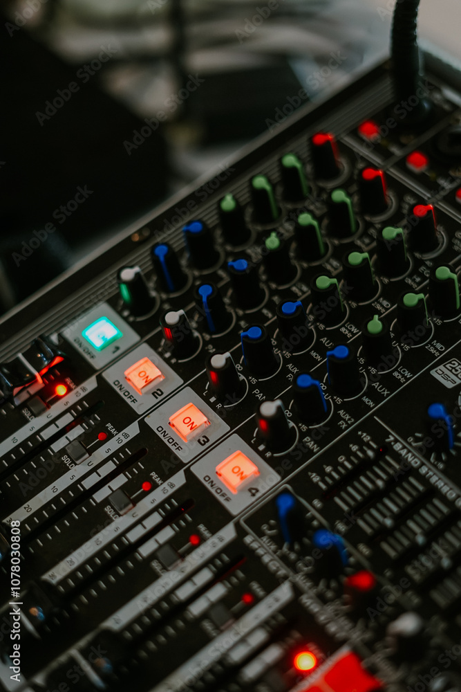audio mixer soundboard with various knobs, sliders, and indicator lights