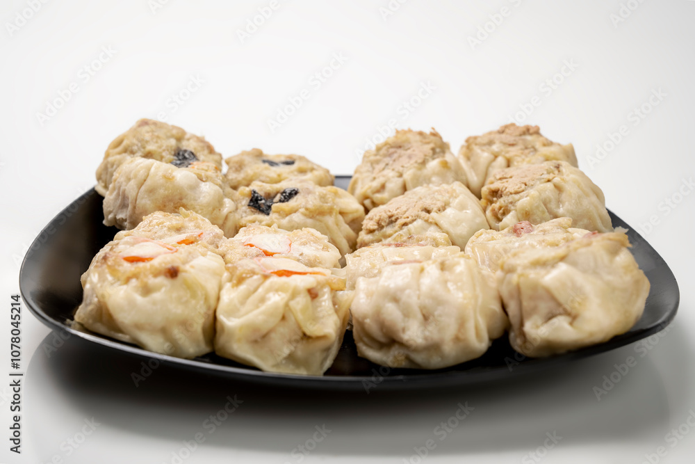 Assorted chinese dim sum dumpling on the plate isolated over white background Assorted chinese dim sum dumpling on the plate isolated over white background