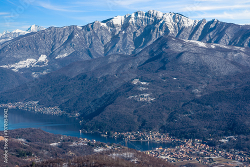 Lake Lugano and the town of Porto Ceresio (Valceresio), Italy, in winter with snow, on the border with Switzerland. Left, the Swiss village of Brusino Arsizio and in the background, Mount Generoso
