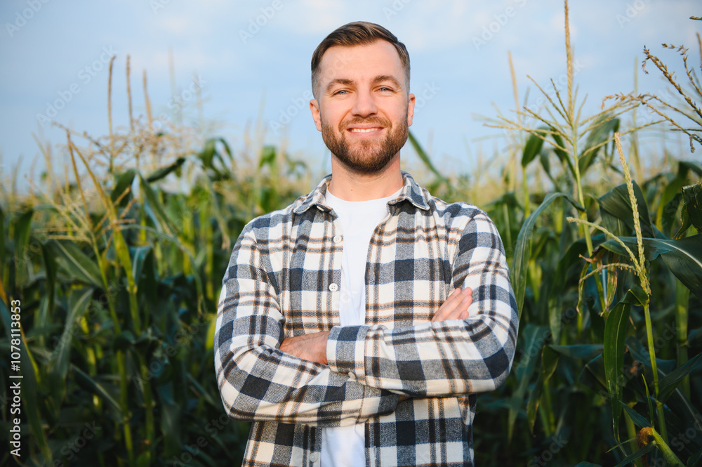 Yong handsome agronomist in the corn field and examining crops before harvesting Yong handsome agronomist in the corn field and examining crops before harvesting