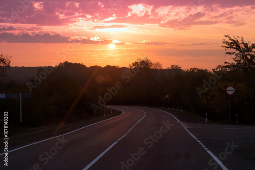 Empty long mountain road to the horizon on a sunny summer day at bright sunset - speed motion blur effect