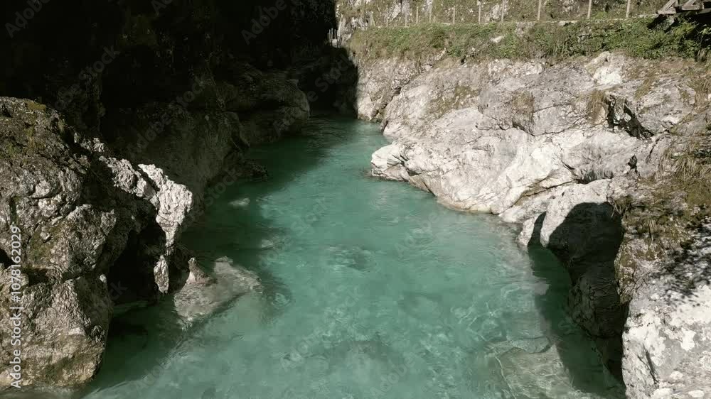 Aerial view of Tolmin Gorges, Slovenia: turquoise river winding through steep, lush green cliffs, narrow pathways, and misty atmosphere in a stunning natural canyon. Aerial view of Tolmin Gorges, Slovenia: turquoise river winding through steep, lush green cliffs, narrow pathways, and misty atmosphere in a stunning natural canyon.