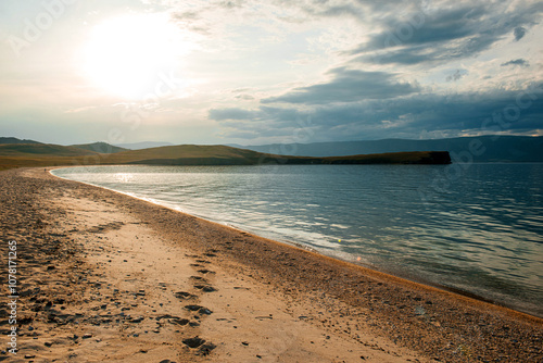 the sandy shore of Lake Baikal at sunset photo