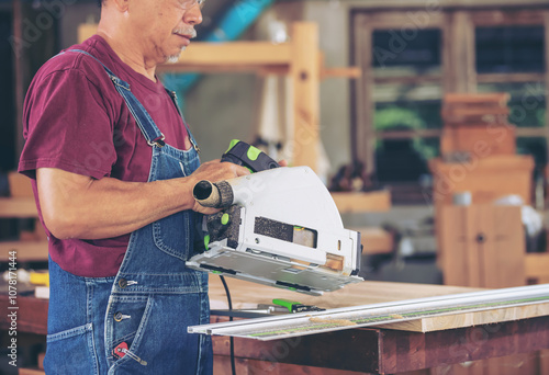 Confident senior male carpenter stands firm in his carpentry workshop, living a happy life working with wood and making furniture.