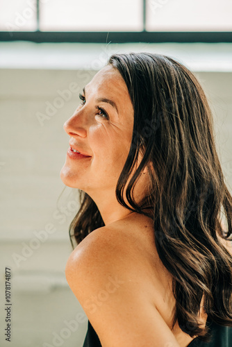 Woman looking upward with a soft smile, captured in natural light photo