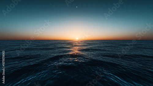 Obraz na płótnie Vibrant sunrise over a calm ocean with reflections on water surface under a clear sky, creating a serene and peaceful seascape backdrop. w salonie