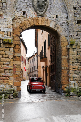 Ancient gate to city of Volterra with classic car. Volterra, Tuscany, Italy